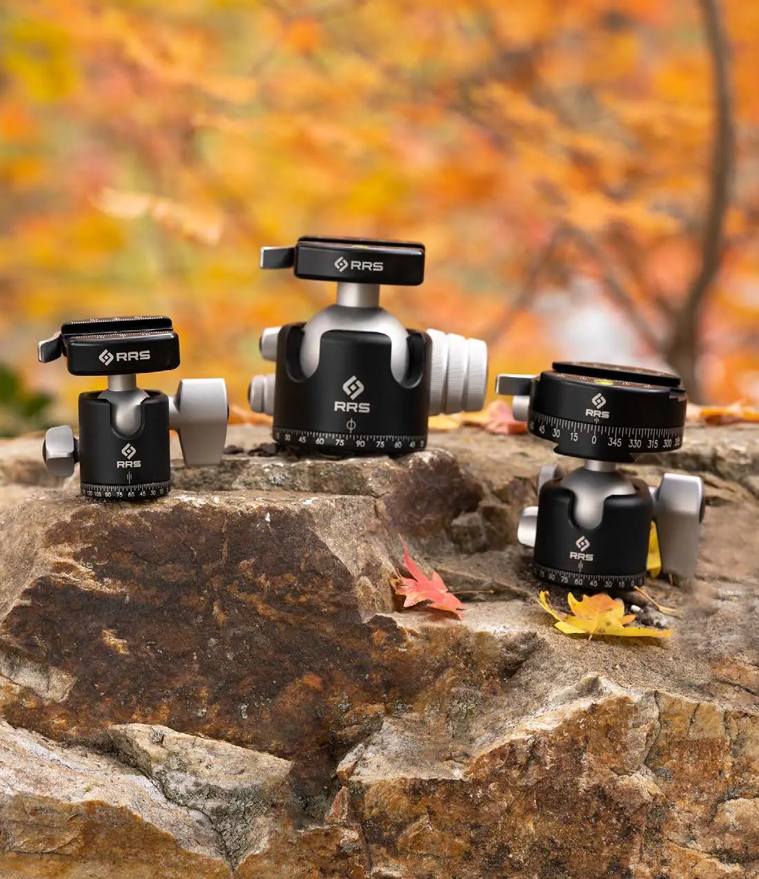different ball heads displayed on a rock with a fall background